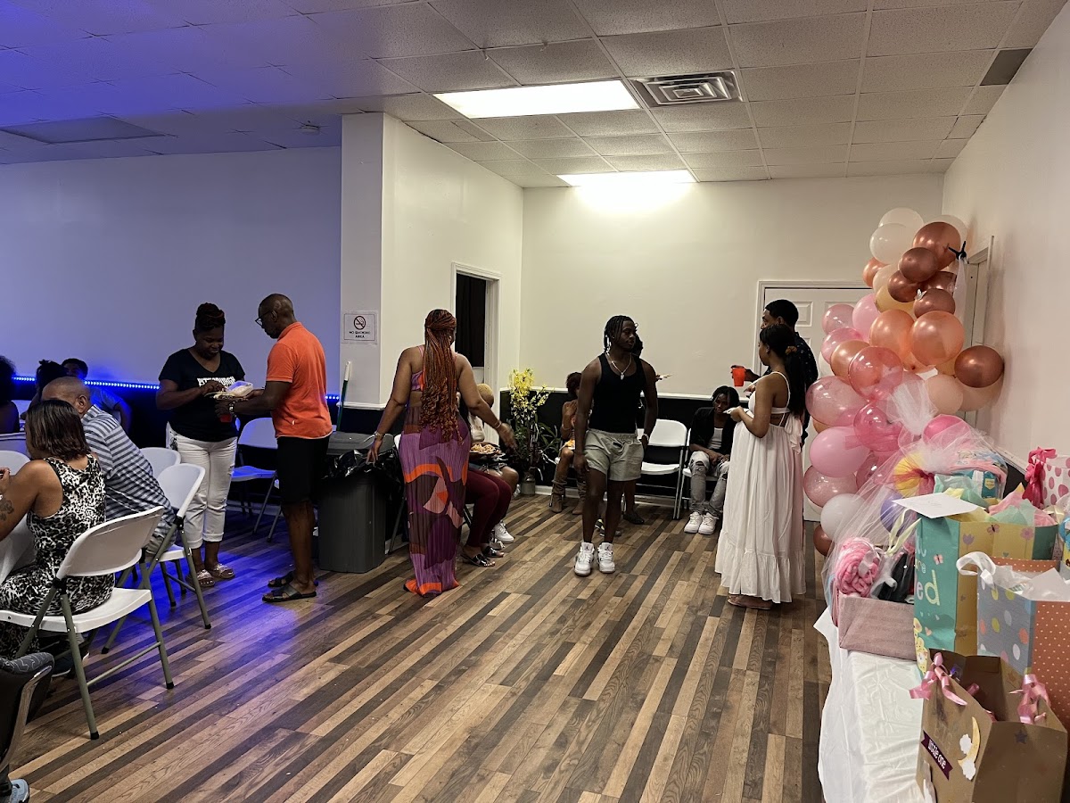 Guests gathered for a baby shower with a balloon display and gift table at The Complexx ATL
