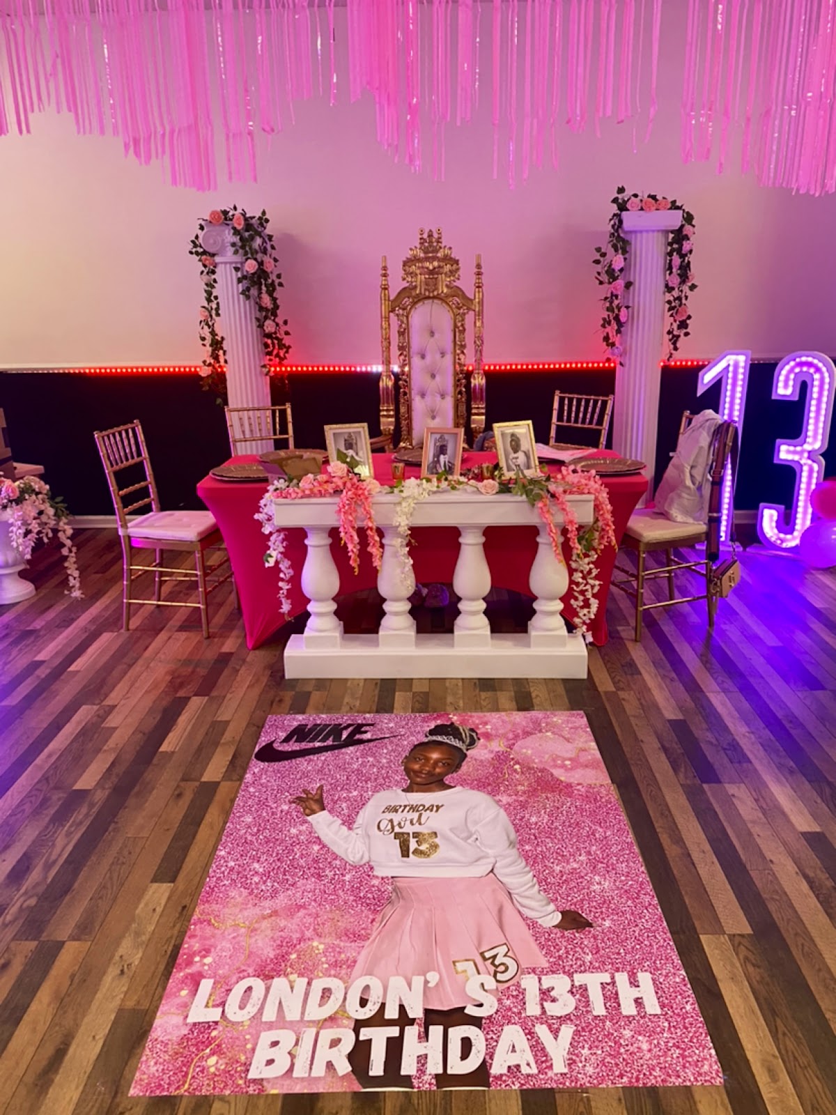 A birthday party set up in the event space with a throne backdrop, columns, and pink decor