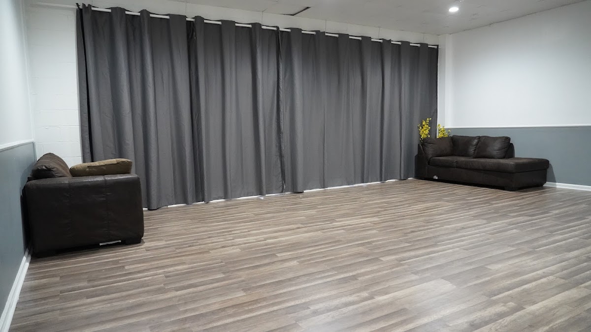 The open, blank-canvas event room at The Complexx ATL with hardwood floors and soft lounge seating